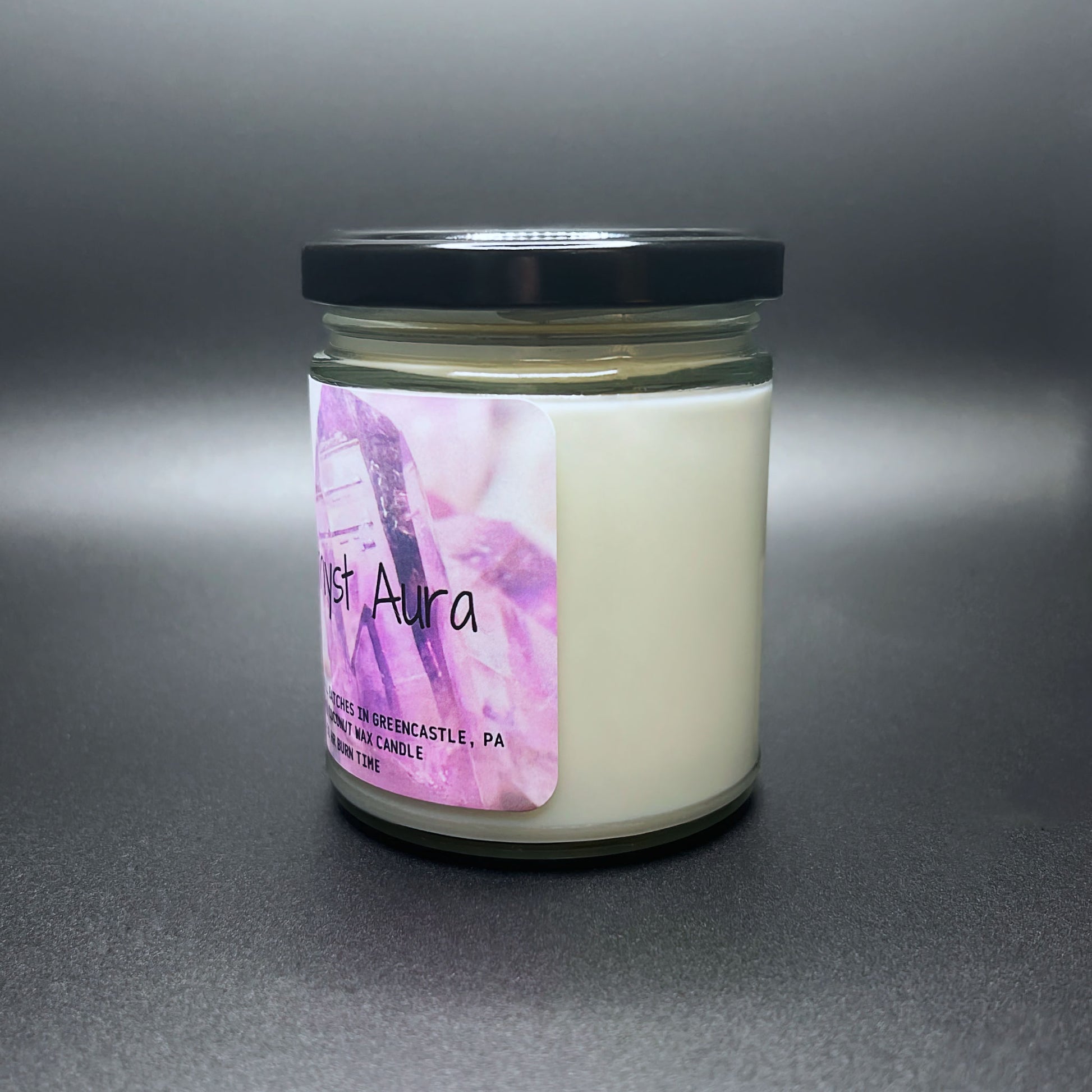 Amethyst Aura candle with purple crystal label on grey background.