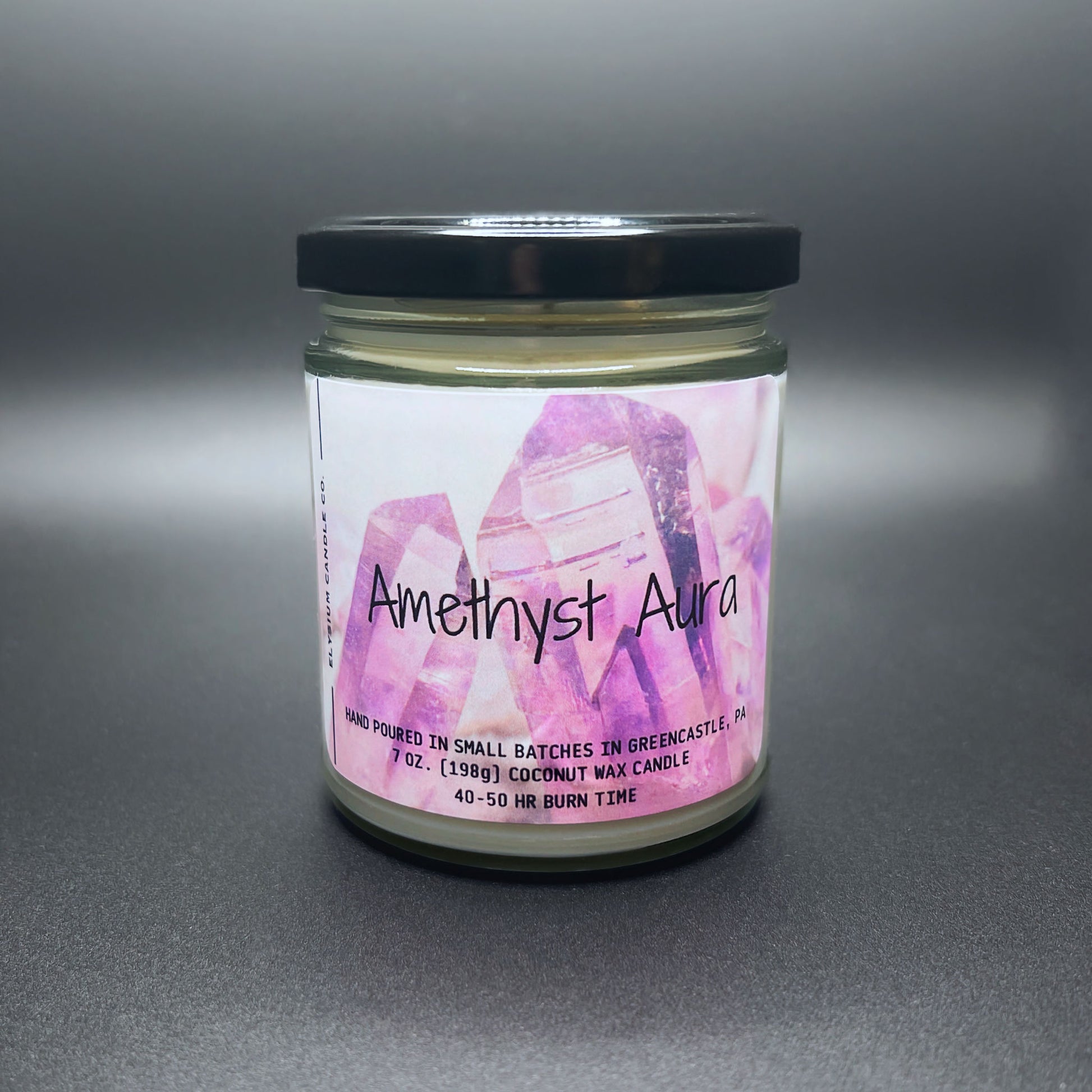 Front view of Amethyst Aura candle, crystal design label, dark lid.
