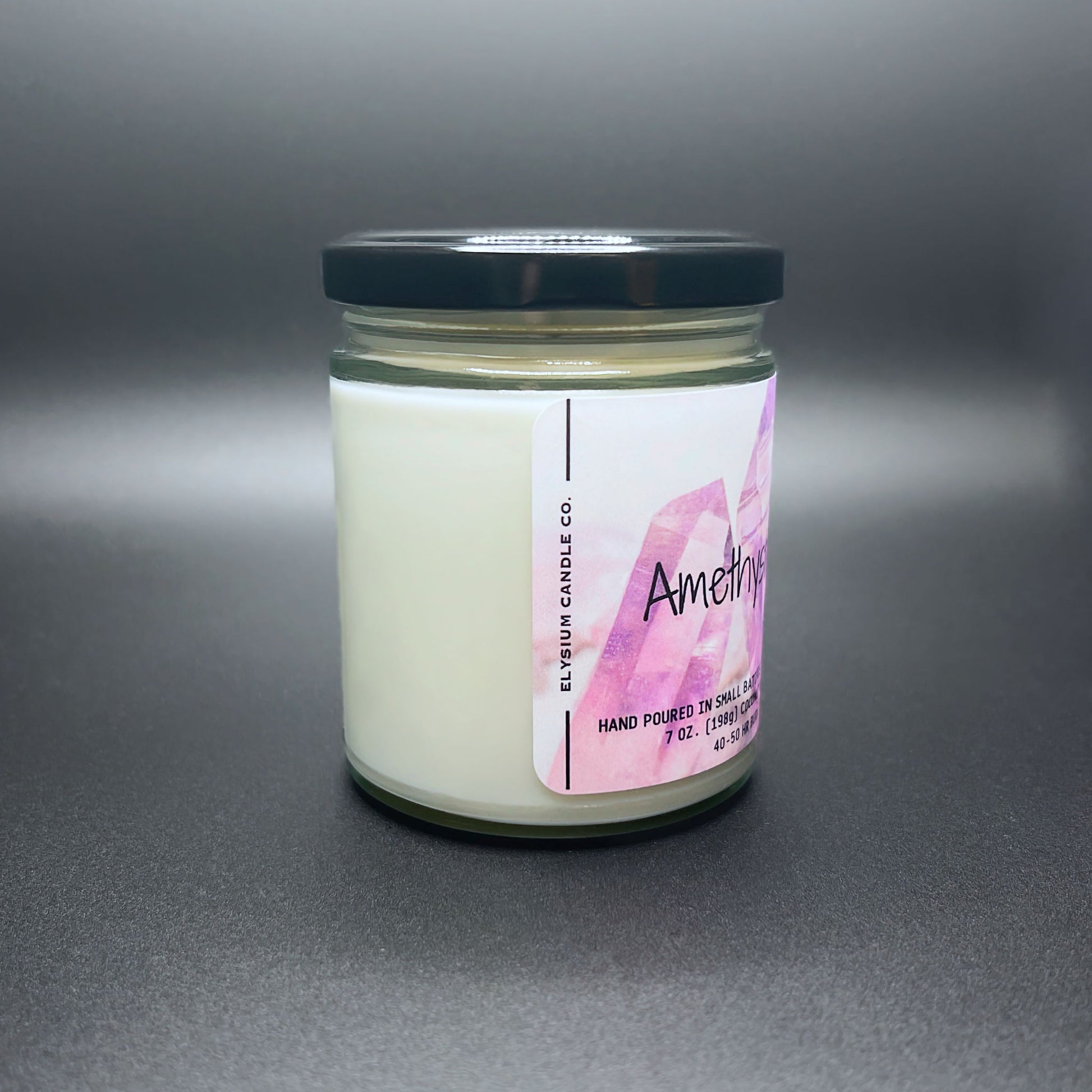 Side view of Amethyst Aura candle, purple label, white wax, black lid.
