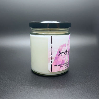 Side view of Amethyst Aura candle, purple label, white wax, black lid.