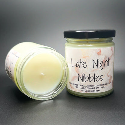 Open jar of Elysium Candle Co.’s Late Night Nibbles candle, showcasing the smooth coconut soy blend wax and a whimsical label with watercolor snack illustrations.