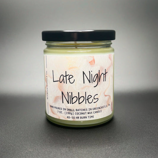 A cozy jar candle called ‘Late Night Nibbles’ by Elysium Candle Co., showing a watercolor-style label, hand-poured coconut soy wax blend, with a 40-50 hour burn time.