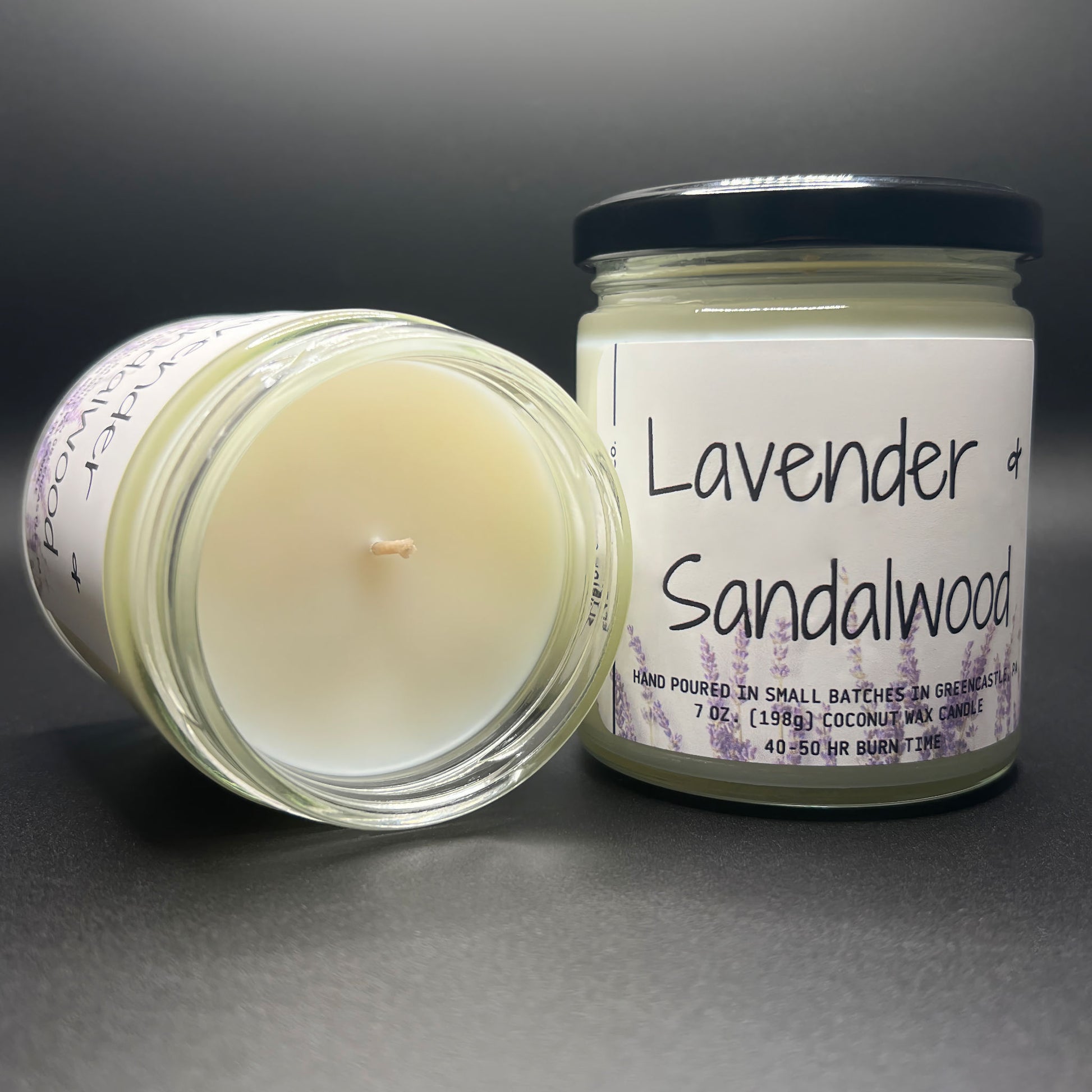 Top view of an open Lavender and Sandalwood coconut-soy candle by Elysium Candle Co., showcasing the smooth, creamy wax surface with a single centered wick. The edges of the label visible around the rim, hinting at hand-poured small batch craftsmanship.