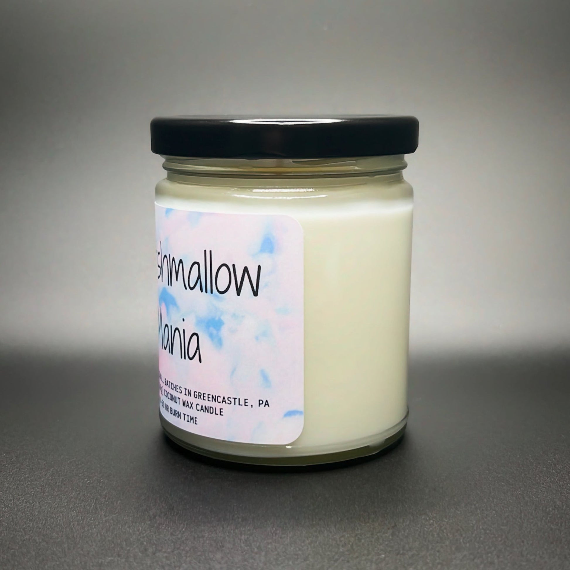 A premium Marshmallow Mania candle from Elysium Candle Co. with a hand-poured coconut soy wax blend in a jar, detailed with a softly hued, artistic label.