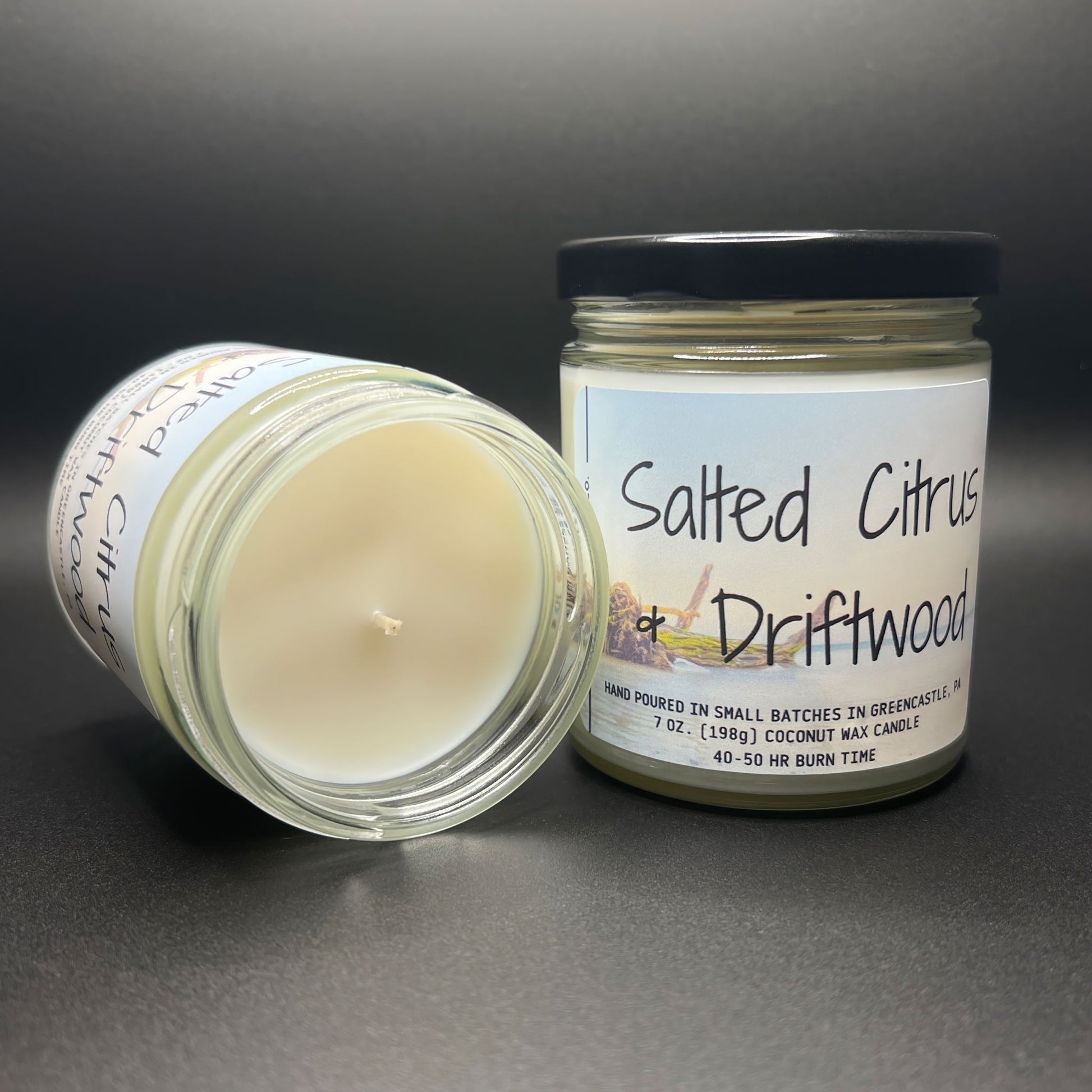 Top-down view of an open Salted Citrus and Driftwood coconut wax candle, showcasing the unlit wick and the uniform, smooth surface of the natural wax, with part of the label visible around the rim of the jar.