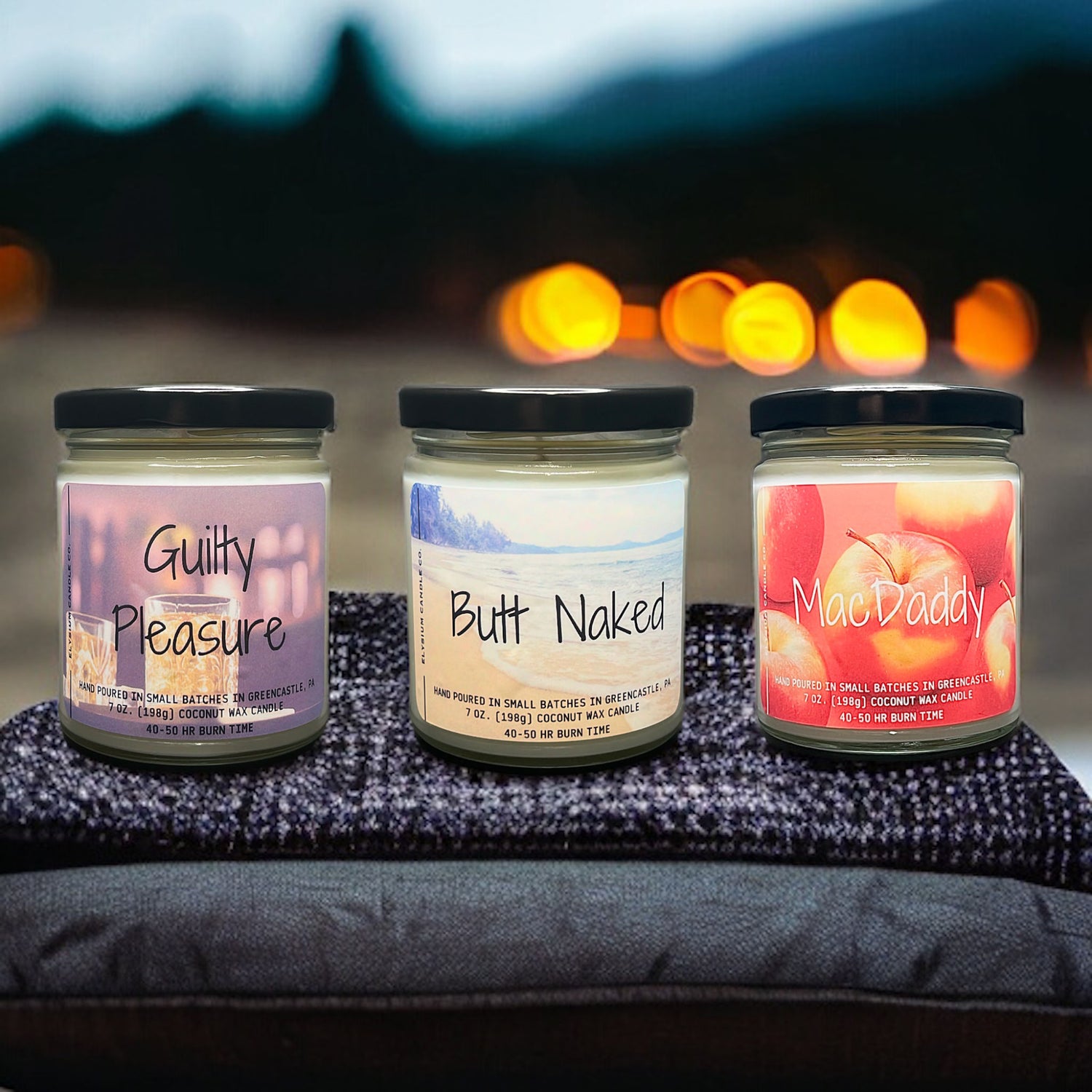 Three uniquely named coconut soy wax candles displayed against a blurred background of twilight and lights, each with distinct, vibrant label designs indicating hand-poured quality and enticing fragrances.